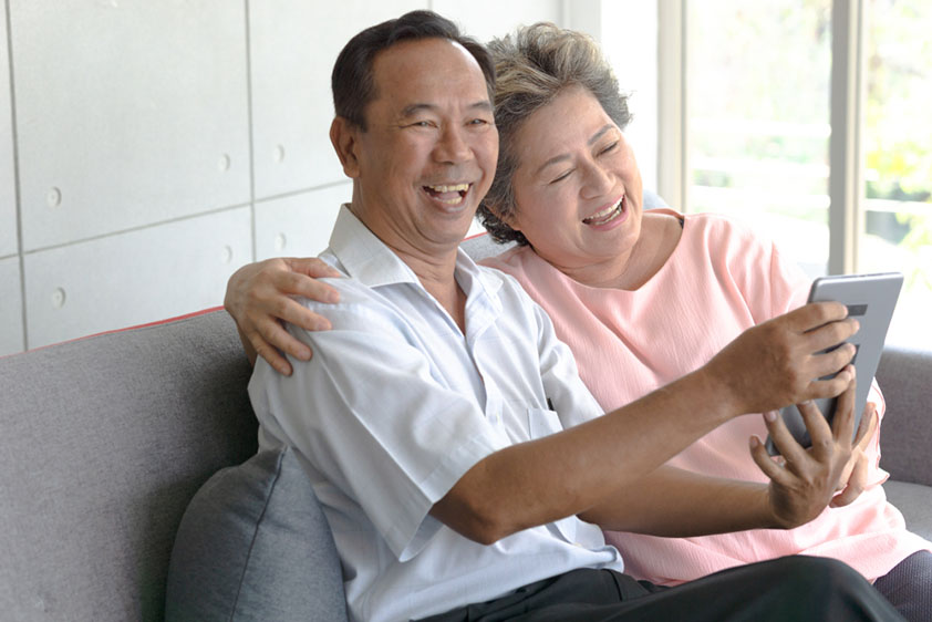 Middle-aged Asian couple looking at tablet