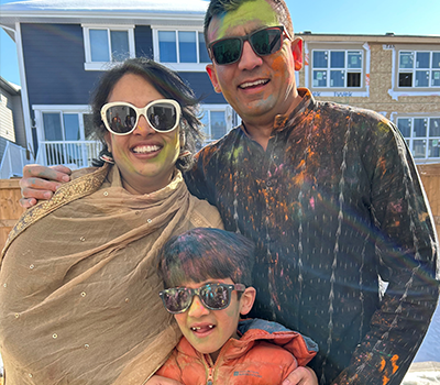 Shivika and family wearing sunglasses covered in colourful Holi powder.