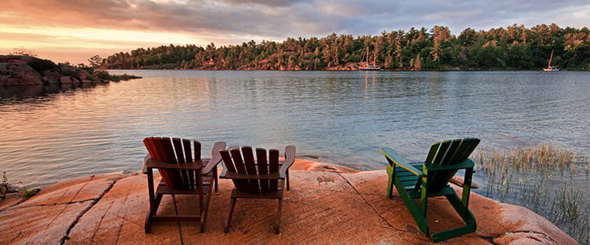 3 Muskoka chairs by the water